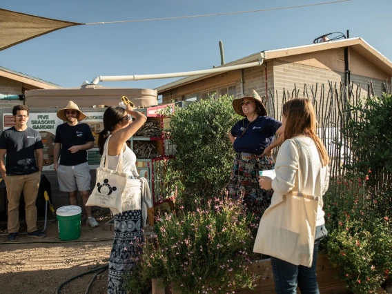 People stand outdoors at a community garden.