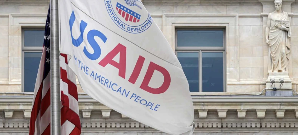 A photo of the United States flag and flag of the USAID agency.